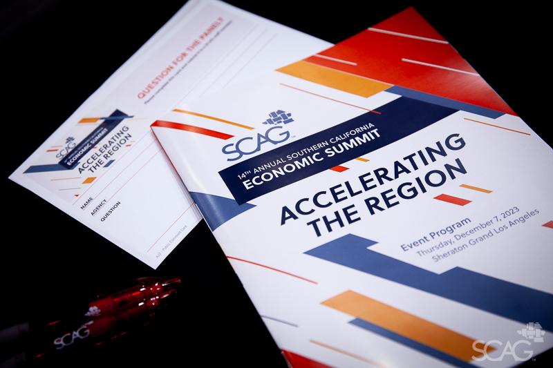 "Regional Briefing Book" and other event materials on a table.
