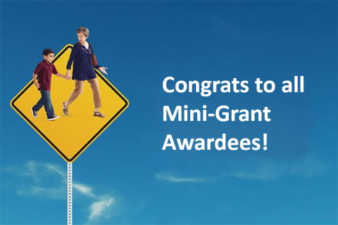 Traffic sign with adults and child walking, blue sky background.