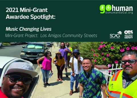 Group of people smiling outdoors, one in a safety vest, sunny day.